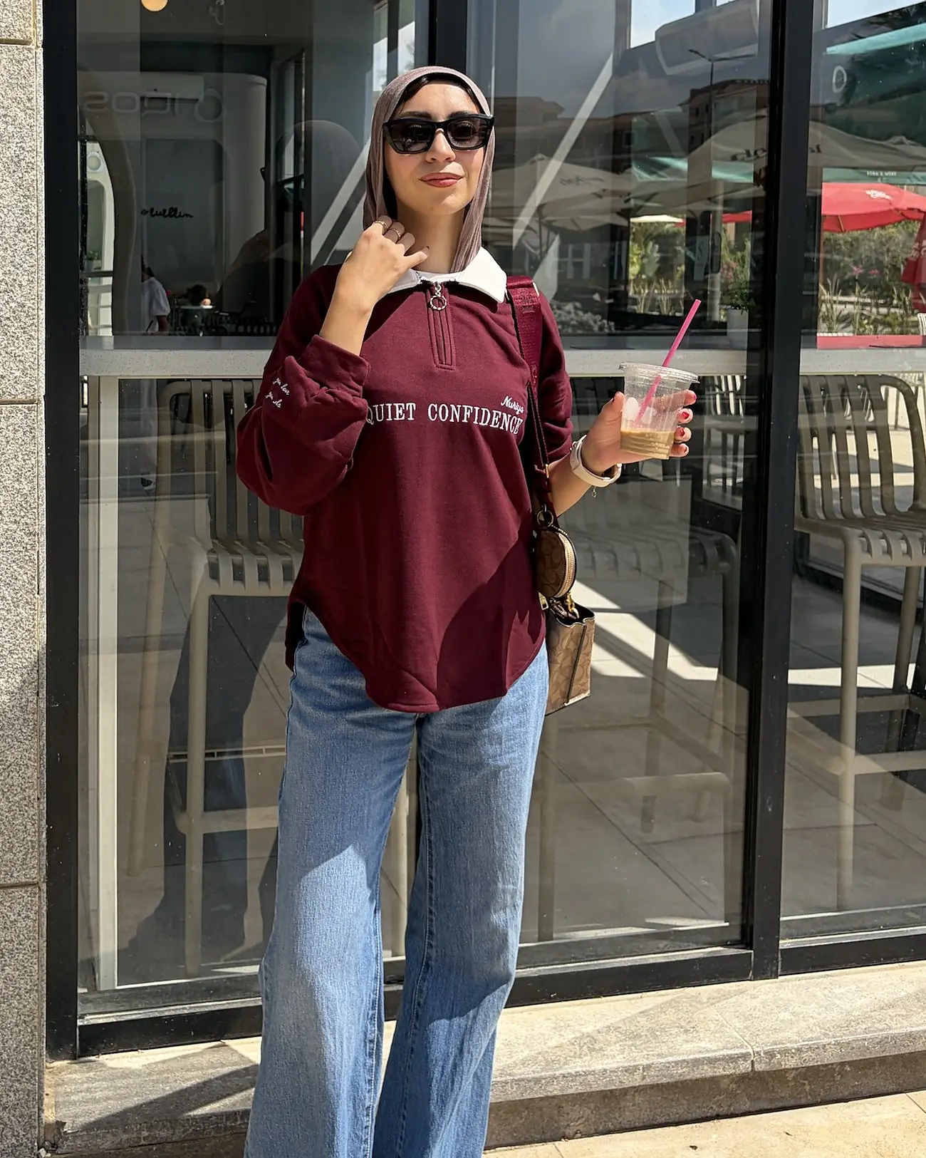 Burgundy quarter-zip worn with jeans, hand at the white collar